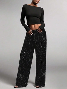 Detail view of shimmering sequins on black wide leg trousers for party wear