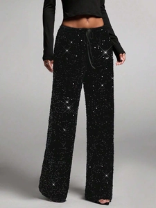 Detail of high-density black sequins and drawstring waistband on fashion trousers