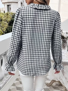 Detail of ruffle cuff and gingham check pattern on long sleeve shirt for women