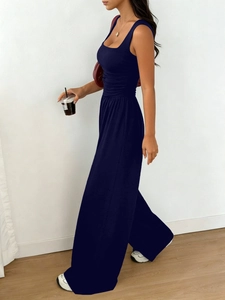 Detail of navy blue sleeveless jumpsuit with square neck and pleated waistline