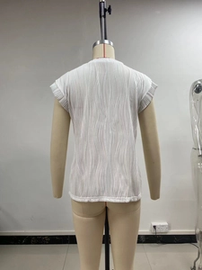 Detail view of the vertical wave-pleated texture on a white short sleeve top for women