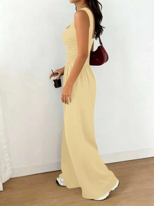 Detail of cream-colored sleeveless top with pleated texture and wide-leg trousers