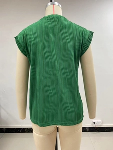 Detailed view of emerald green textured pleats on relaxed-fit summer top