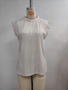 Close-up of beige sleeveless top featuring vertical pleated texture and stand collar