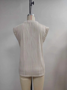 Detail of off-white ripple textured fabric on short sleeve top with high neckline