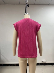 Detail of rose red sleeveless top featuring vertical wavy pleated fabric texture