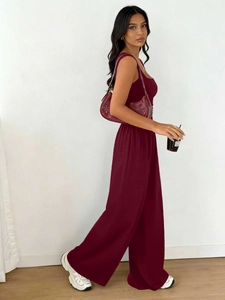 Detailed view of burgundy sleeveless top and wide-leg trousers set with elegant drape