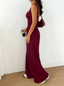 Detail of burgundy sleeveless wide-leg jumpsuit with pleated waist and square neckline