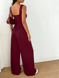 Detail of burgundy sleeveless jumpsuit with square back design and elegant waist pleats