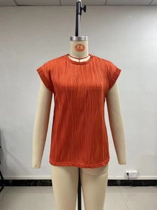 Detailed view of orange pleated texture on a sleeveless crewneck summer blouse for women