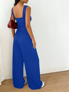 Detail of royal blue square neck top and high-waist wide-leg trousers from back side view