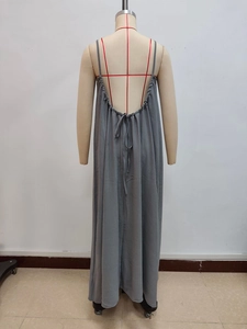 Detail view of the backless design with thin spaghetti straps and tied closure on grey dress