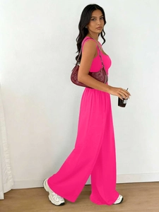 Detail view of vibrant rose red sleeveless top and wide leg pants set with shoulder bag