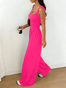 Detail of hot pink sleeveless jumpsuit featuring pleated waist and wide leg cut
