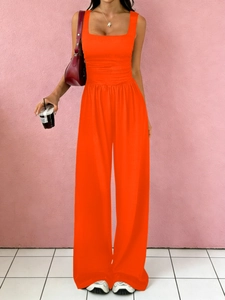 Detail view of the high-waisted wide-leg trousers with pleated waist design in orange