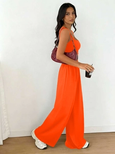 Model wearing orange two-piece set featuring sleeveless tank top and wide leg trousers