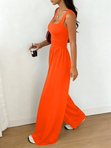 Detail of orange sleeveless square neck top and wide leg pants set with pleated waist