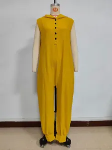 Detail of yellow hooded jumpsuit featuring a buttoned neckline and textured fabric