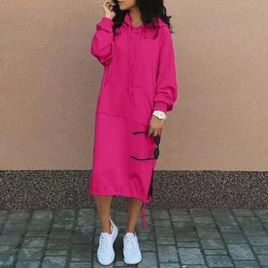 Outdoor shot of a loose rose red longline hoodie dress with kangaroo pocket and drawstring