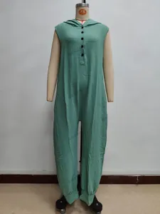 Detail of green sleeveless jumpsuit showing vertical pleated texture and button hooded neck
