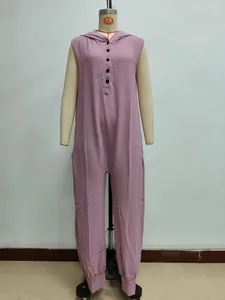 Detail of mauve sleeveless hooded jumpsuit featuring black buttons and textured fabric
