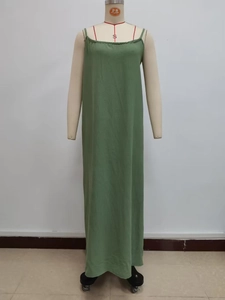 Front view detail of a light green loose camisole maxi dress with fine straps and texture