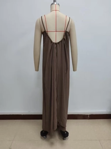 Close-up of brown halter backless dress with thin straps and draped fabric on a mannequin