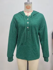 Detail of green hooded jacket featuring unique horizontal pleated texture and buttons