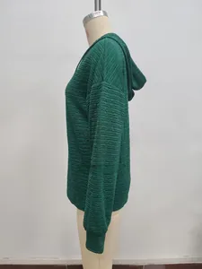 Detailed view of dark green long sleeve hoodie featuring unique plissé pleated fabric texture
