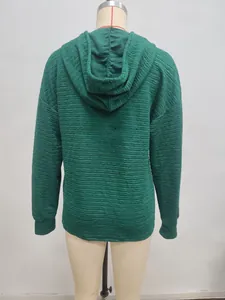 Detailed view of the dark green hoodie featuring unique textured crinkle fabric design