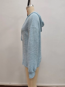 Detail of light blue hooded jacket featuring unique horizontal wave pleated texture fabric