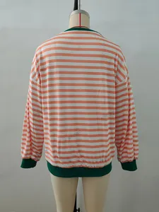 Detail of orange and white striped sweatshirt with dark green ribbed crew neck and cuffs