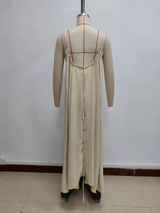 Back view of a beige backless maxi dress with thin straps on a mannequin stand