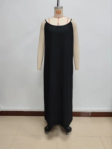Detailed view of black pleated long dress featuring thin straps and loose vertical silhouette