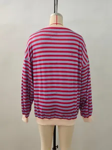 Detail of red and grey-blue striped knit sweater with ribbed beige cuffs and neckline