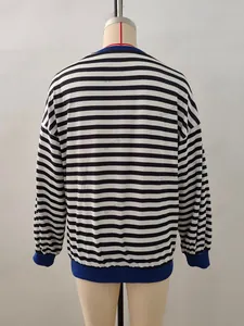 Detail of blue ribbed neckline and cuffs on a black and white striped long sleeve top
