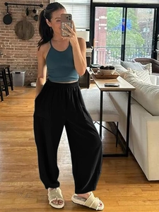 Detail view of black high-waisted wide-leg trousers with elastic waistband and soft drape