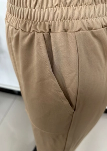Detail of camel casual trousers featuring elastic drawstring waist and side pockets