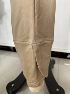 Close-up of khaki casual pants featuring a stylish overlapped side slit and neat stitching