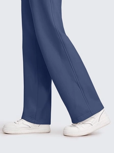 Detail view of navy blue wide leg pants with side stitching and white sneakers