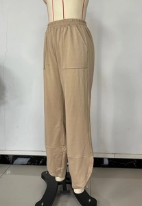 Detail of beige casual pants showing elastic waistband and large functional patch pockets