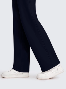 Detail view of navy blue wide-leg sports pants paired with white leather sneakers