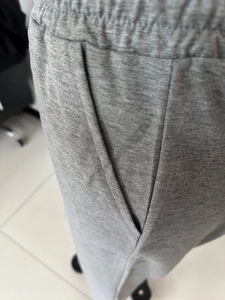 Detailed view of elastic waistband and side pocket stitching on gray cotton joggers
