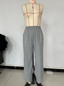 Detail view of deep grey knitted joggers featuring an elastic waistband and dual patch pockets