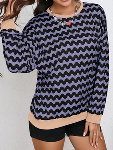 Detail of wavy purple and black striped sweatshirt with ribbed cuffs and round neckline