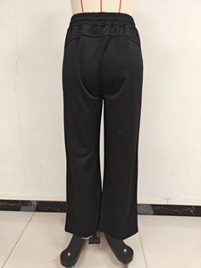 Detail of high-waist elastic drawstring on black wide-leg joggers with premium draping