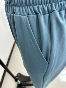 Detail of elastic waistband and side pocket on gray-blue casual athletic trousers