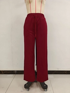 Detail of high waist elastic waistband and matching drawstring on burgundy wide leg pants