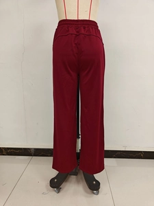 Detail view of burgundy wide-leg pants with elastic high waist and draped fabric back