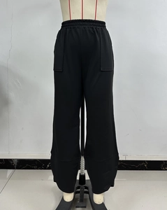 Detailed view of high-waisted elastic waistband and functional patch pockets on black pants
